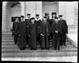 Photograph: [Ten unidentified men in caps and gowns pose on steps]