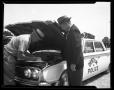 Primary view of [Andy Anderson and Pedro Parsons in front of a City of Denton police car]