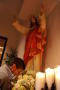 Photograph: [Parishioner prays under statue of Jesus]