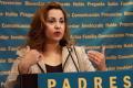 Photograph: [Lydia Gonzalez Welch speaking behind podium and gesturing toward her…