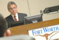 Photograph: [Jose Legaspi standing behind podium with "Fort Worth" sign]