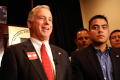 Primary view of [Howard Dean and three other men in front of NALEO seal]