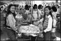 Photograph: [Two Women display food from a Chinese Food Booth]