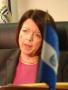 Photograph: [A Woman, Consul of El Salvador, with the flag of El Salvador on her …