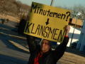 Primary view of [Man holding protest sign overhead]