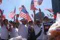 Photograph: [Immigration Protesters Carry Flags and Signs]
