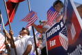 Photograph: [Immigration Protesters Hold Signs and American Flags]