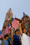 Photograph: [Protesters march and wave American flags as they pass Cathedral Sant…