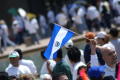 Photograph: [The flag of El Salvador is held up during march]