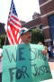 Photograph: [Protester with an American flag and a sign, "We Stand for Justice"]