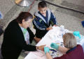 Photograph: [Woman has a blood test while a little boy looks on]