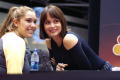 Photograph: [Gabriela leans across table to have picture taken with young woman]