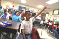 Primary view of [Students raise their hands during a class at Crockett Elementary]