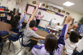Primary view of [Students raise their hands during a class at Crockett Elementary School]