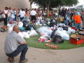 Primary view of [Crowd of people with bags of clothing on ground]