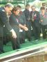 Thumbnail image of item number 1 in: '[Man and woman placing flowers on casket lowered into ground]'.