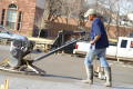 Photograph: [Man pushing heavy construction equipment]