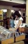 Photograph: [Two young women browsing records at Emily Fowler Library]