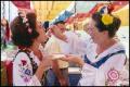 Photograph: [One Woman Feeding Another Woman in Polish Food Booth]