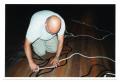 Photograph: [Man Applying Tape Designs to Gallery Floor]