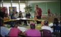 Photograph: [Man with Drawing Speaking to Gates Elementary Classroom]