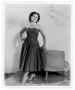 Photograph: Woman standing behind a chair