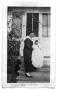 Primary view of Mrs. Kruder holding a baby on the front steps of a house