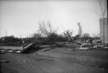 Photograph: [Photograph of Windmill, Fallen Trees and Debris After Tornado]