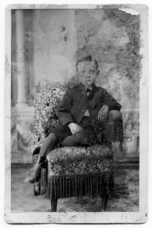 Primary view of object titled 'Boy Sitting in Chair with Tassels'.