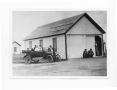 Photograph: [Portrait of People Sitting in a Car and Standing in a Building]