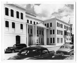 Primary view of object titled '[Cars in front of three-story building]'.