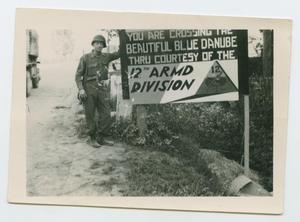 Primary view of object titled '[Soldier Standing by Sign]'.