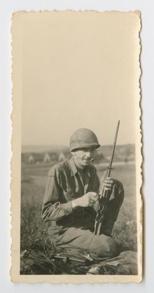 Primary view of object titled '[Tommy Bridges Field Cleaning a rifle]'.