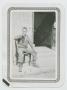 Photograph: [Private McCormick Sitting and Drinking on a Porch]
