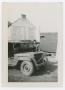 Photograph: [William Giannopoulos Holding a Jeep's Armor Plate]