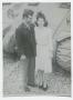 Photograph: [Charles and Anna Woodward Standing by a Tank]