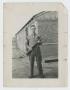 Photograph: [Soldier in Front of Hutment]