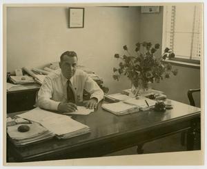 Primary view of object titled '[Photograph of M. Thelin Sitting at Desk]'.
