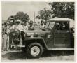 Photograph: [Group of Men Looking at Jeep]
