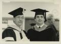 Primary view of [Photograph of Father and Son in Graduation Gowns]