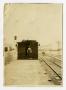 Photograph: [Trainman with Boxcar beside Railroad Tracks]