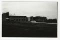 Photograph: [View of Buildings from Across Grassy Field]