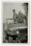 Photograph: [Photograph of a Soldier in a Jeep]