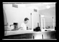 Photograph: [Woman Standing behind Counter]
