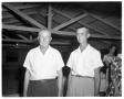 Photograph: [Two Men Under a Wooden Roof Structure]