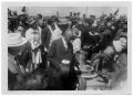 Photograph: [Women in Prairie Dresses Serving Food Among a Crowd]
