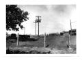 Photograph: [Utility Poles with Barbed Wire Fence]