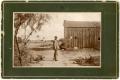 Primary view of [Nathan L. Bartholomew Standing by at  Barn]
