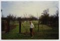 Photograph: [A Man Standing in Front of an Orchard]