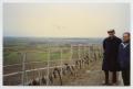 Photograph: [Two Men Standing by a Fence on a Hill]